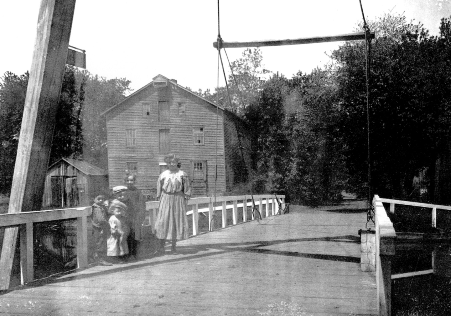 Standing on the deck of the A-frame swingbridge at Griggstown with gristmill in the background; c1900